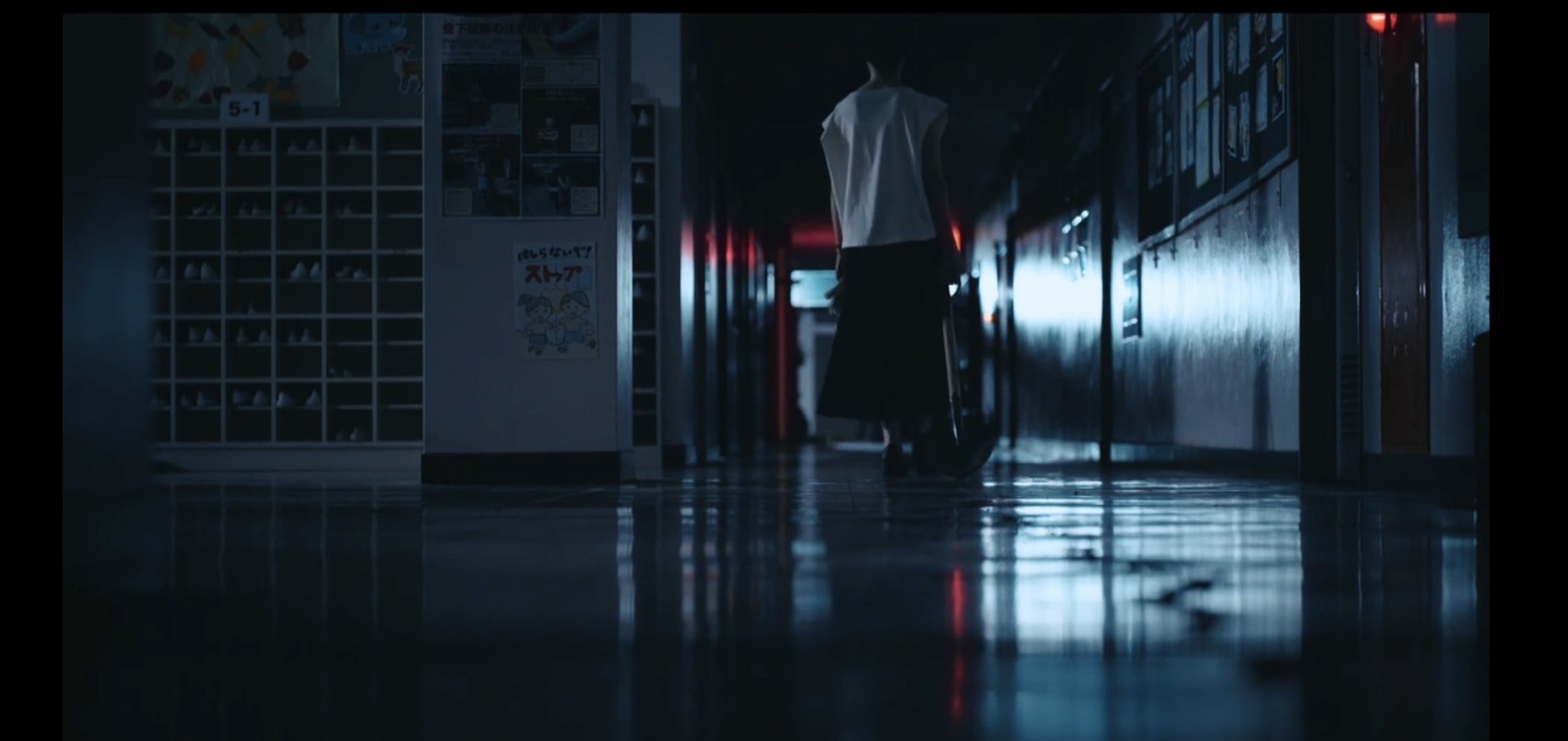 スコップを引きずり学校の廊下を移動する女性